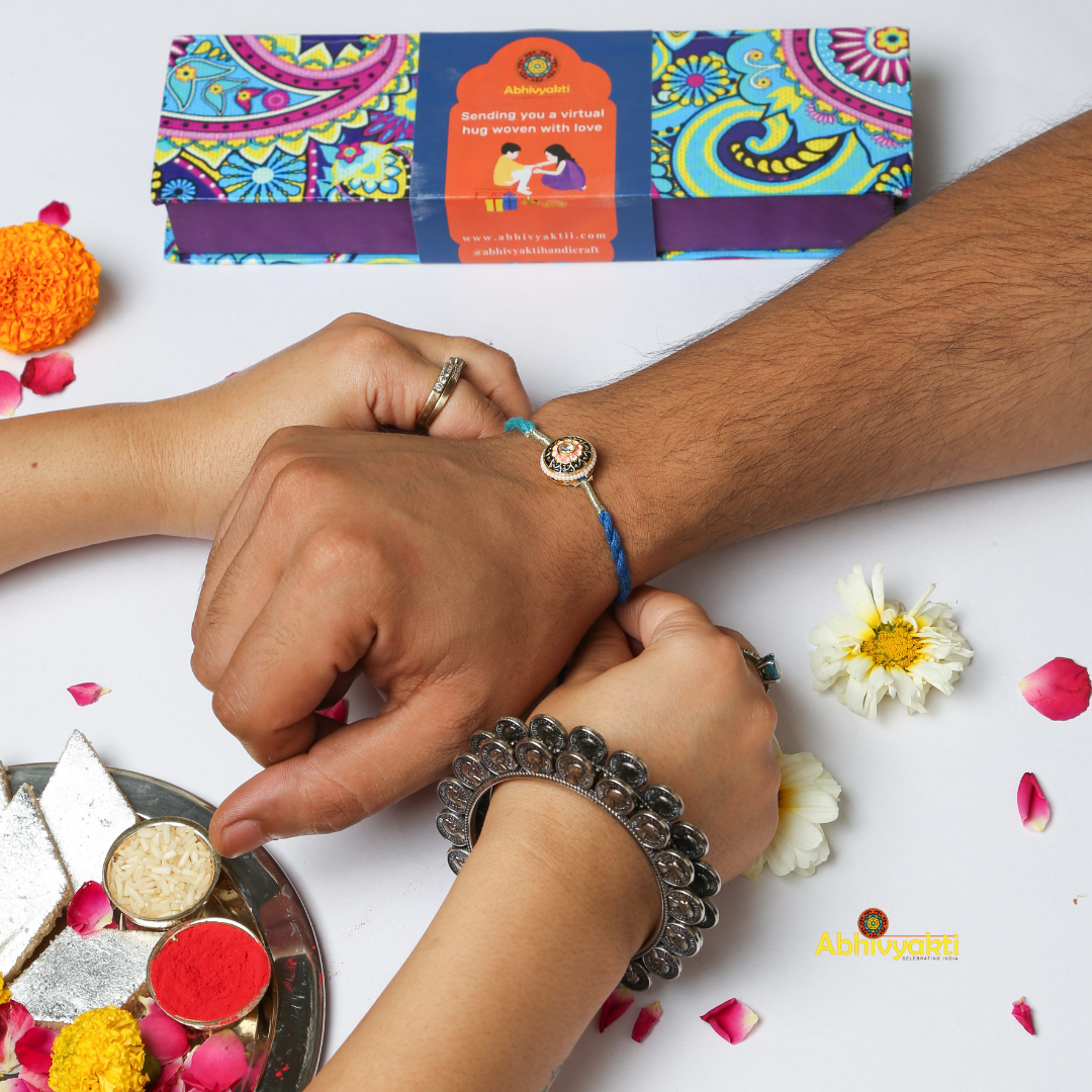 Sister tying a beautiful blue stone rakhi to her brother and celebrating rakshabandhan in traditional Indian way