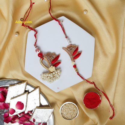A pair of rakhi lumba in red and white colors adorned with pearls, beads, stones, and a unique design