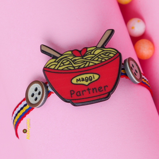 Kids rakhi in red and yellow with beads, noodles, and a button.