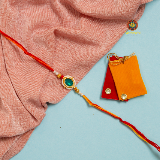 Rakhi with red and yellow string, decorated with colorful stones and beads.