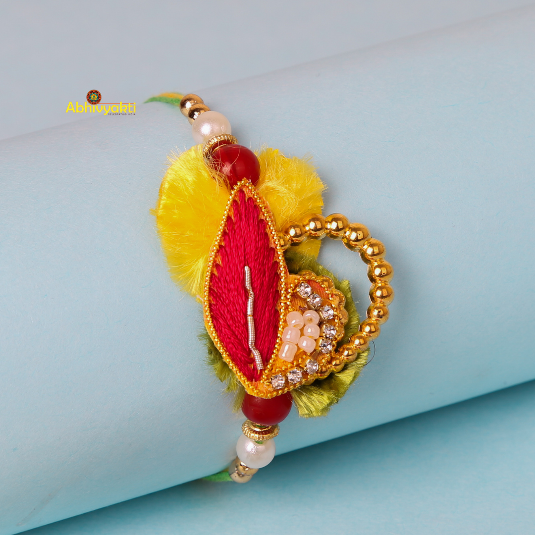 Beautifully crafted rakhi bracelet with yellow and red leaf pattern, accented by a pearl bead.