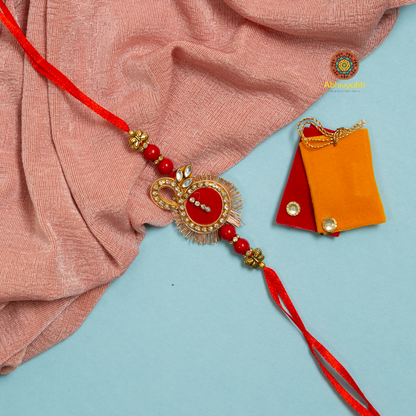 Red and orange rakhi with gold bead, adorned with stone - a beautiful traditional symbol of love and protection.