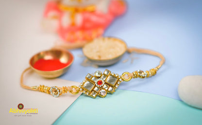 Celebrate Raksha Bandhan with this stunning gold rakhi adorned with a red stone and premium beads.