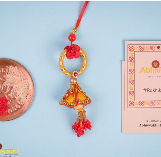 Red and gold featuring a red flower, Rakhi lumba adorned with lovely beads and stone.