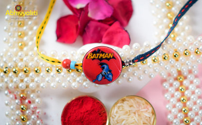 A Rakhi for kids featuring a Batman logo, roli  powder, and lovely beads.