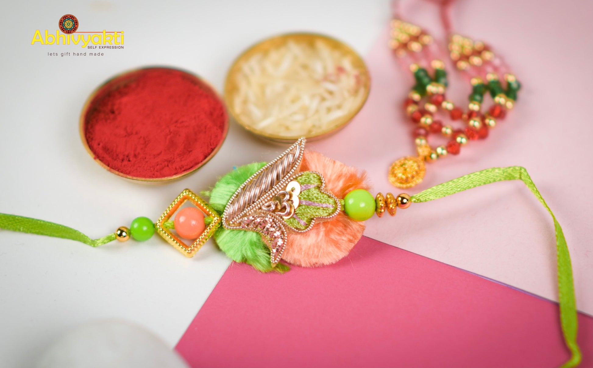 Eye-catching rakhi with a gold and green bead, decorated with stones and a special design.