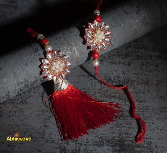 Stunning red and white tasseled rakhi, showcasing kundan rakhi lumba design with intricate beads and stones.