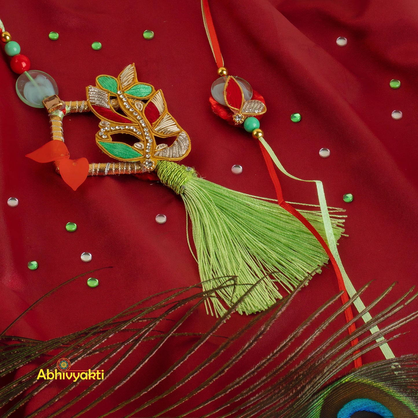 Colorful peacock feather and red/green Rakhi lumba necklace adorned with stones and beads.