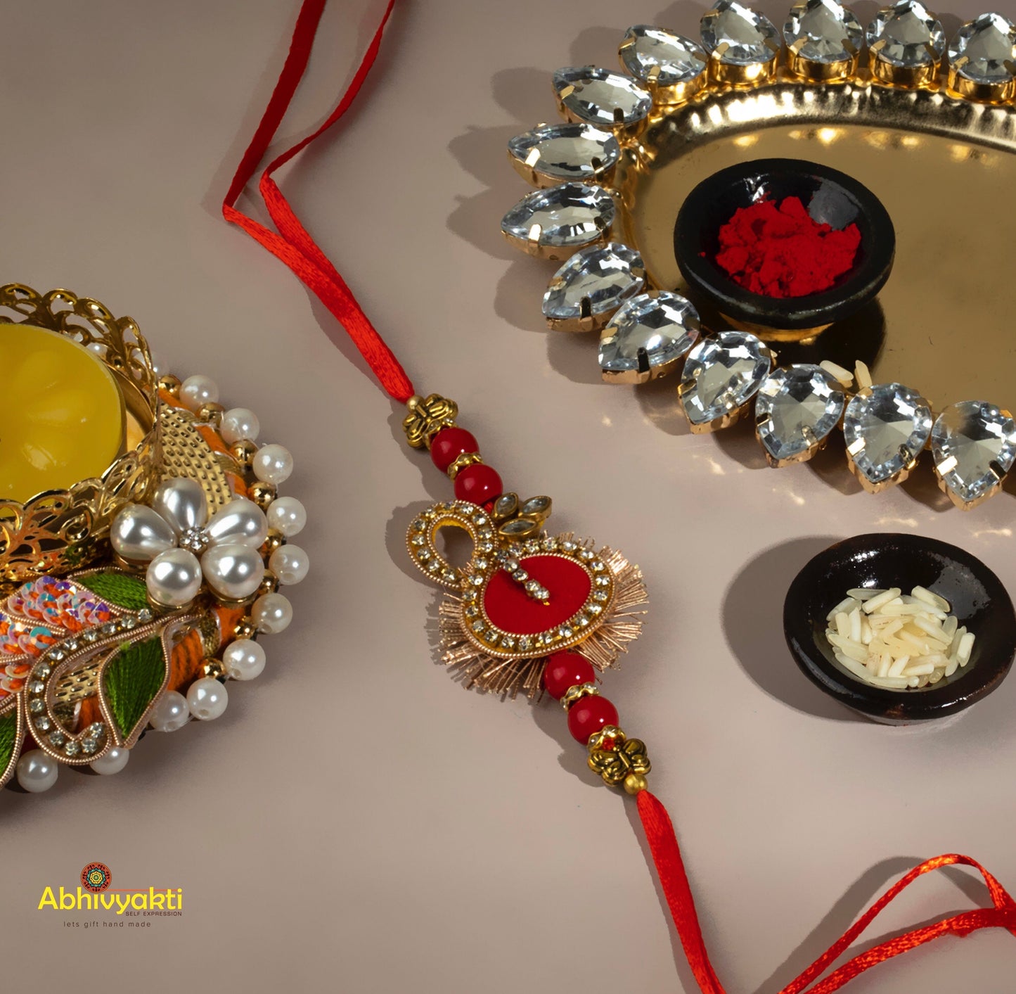 Red and orange rakhi with gold bead, adorned with stone - a beautiful traditional symbol of love and protection.