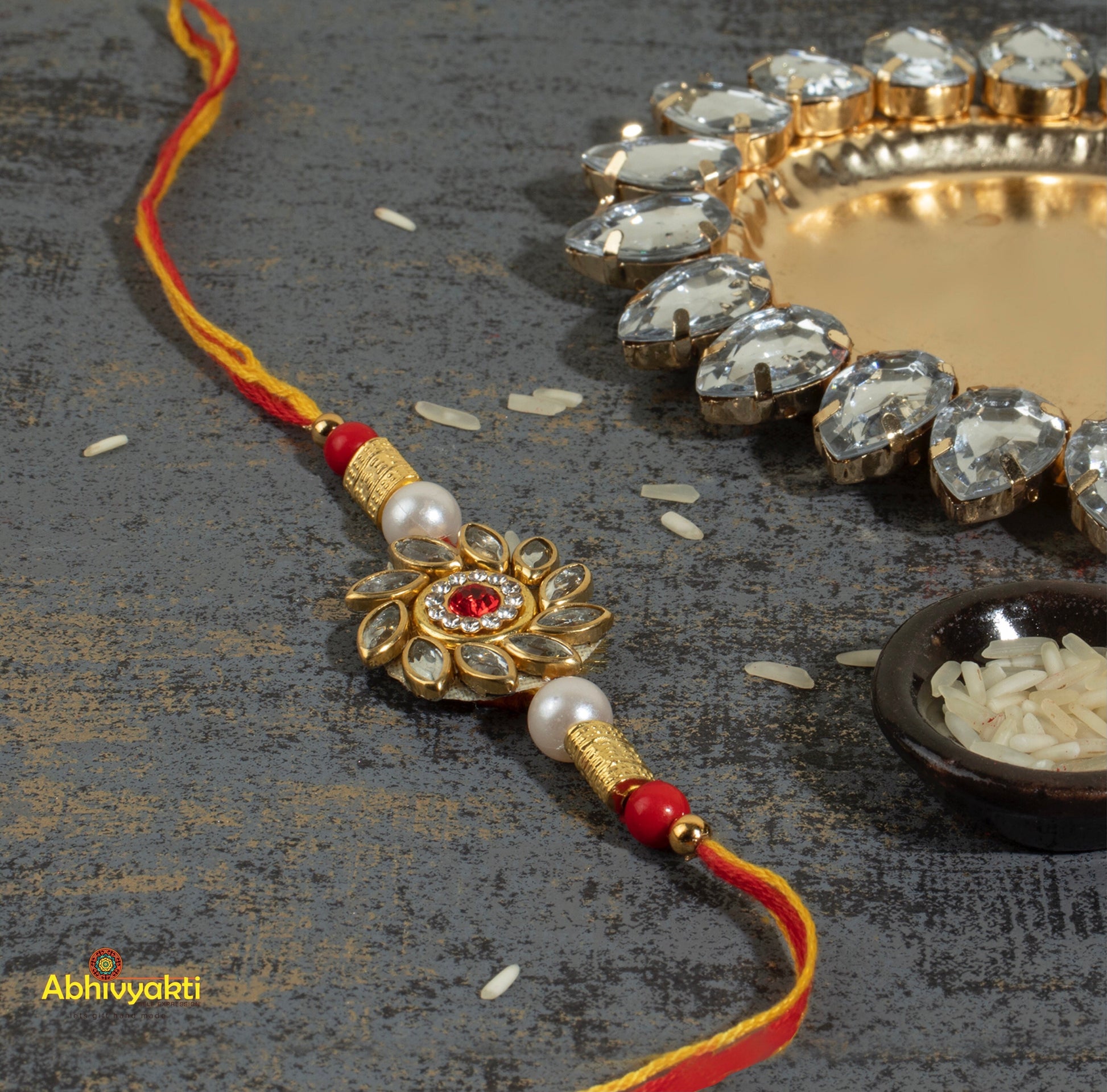 Gold and pearl kundan rakhi with red and white beads, adorned with kundan stone rakhi and beautiful beads.