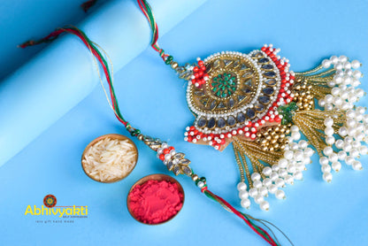 Unique Marwari Rakhi Lumba featuring gold and white colors, beads, stones, and roli powder design.