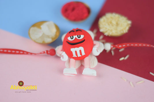 Red and white Rakhi with beautiful beads and an M&M candy for kids.