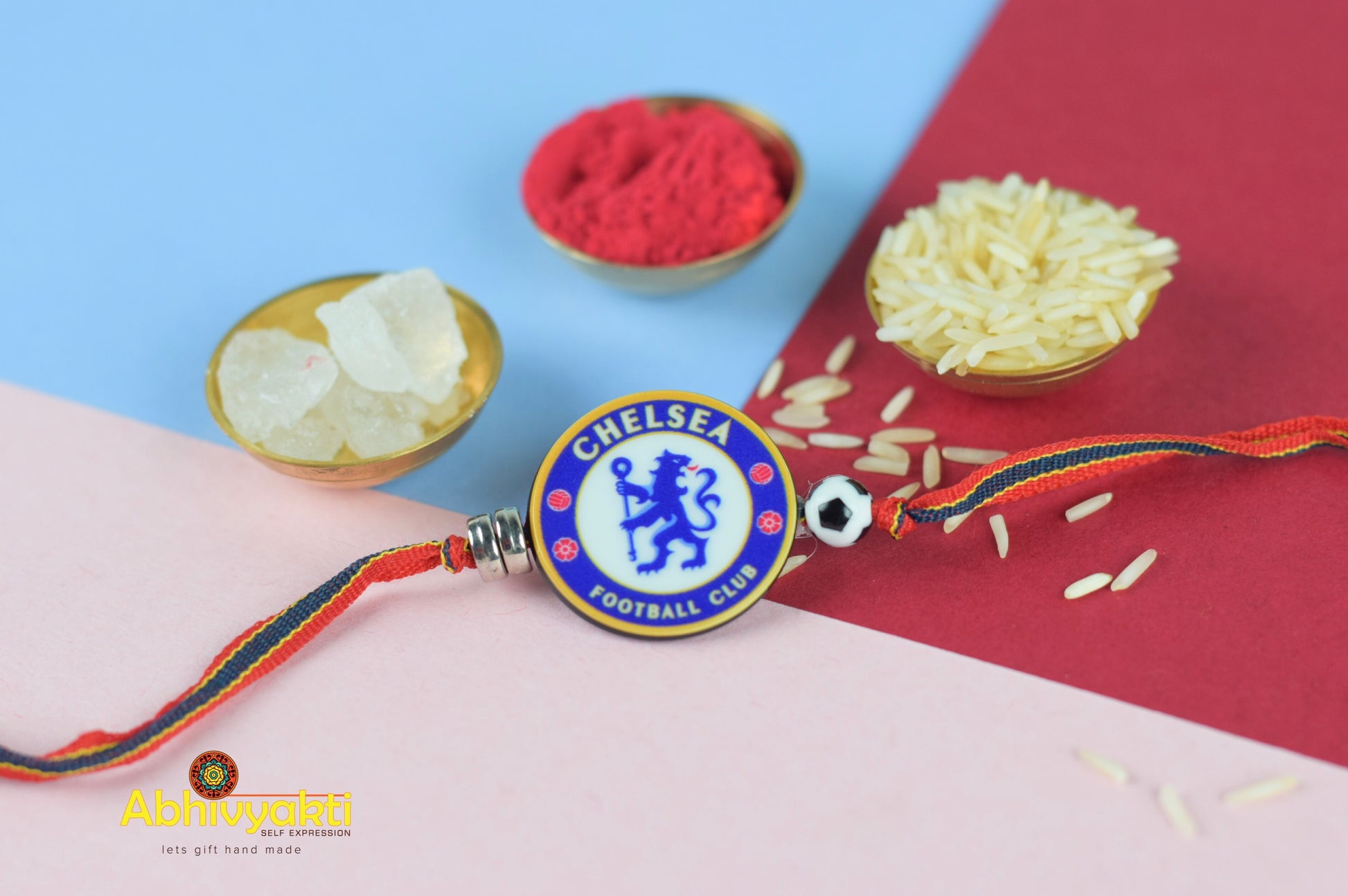 A kids Rakhi with beautiful beads and a Chelsea badge, surrounded by roli and rice.