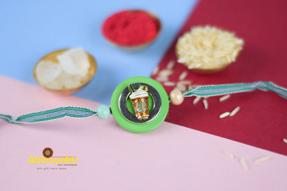 A kids Rakhi featuring starbuck image, green and white with lovely beads.