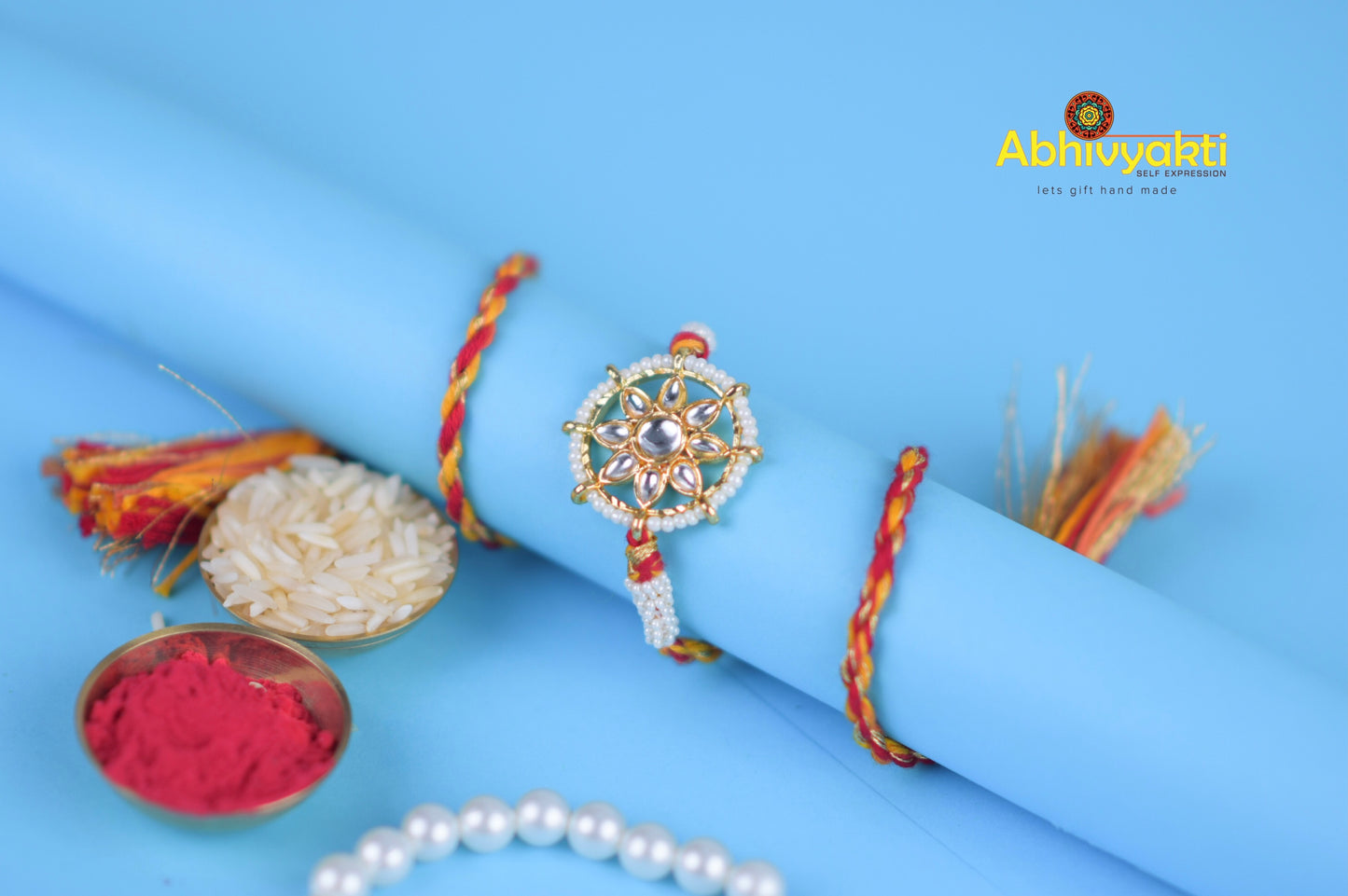 Rakhi bracelet from India featuring pearls and a special stone in wheel design.