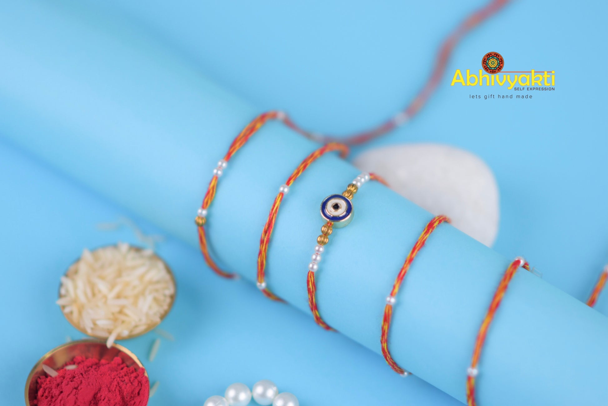 A bracelet adorned with a blue and white evil eye, made of thread with beads.