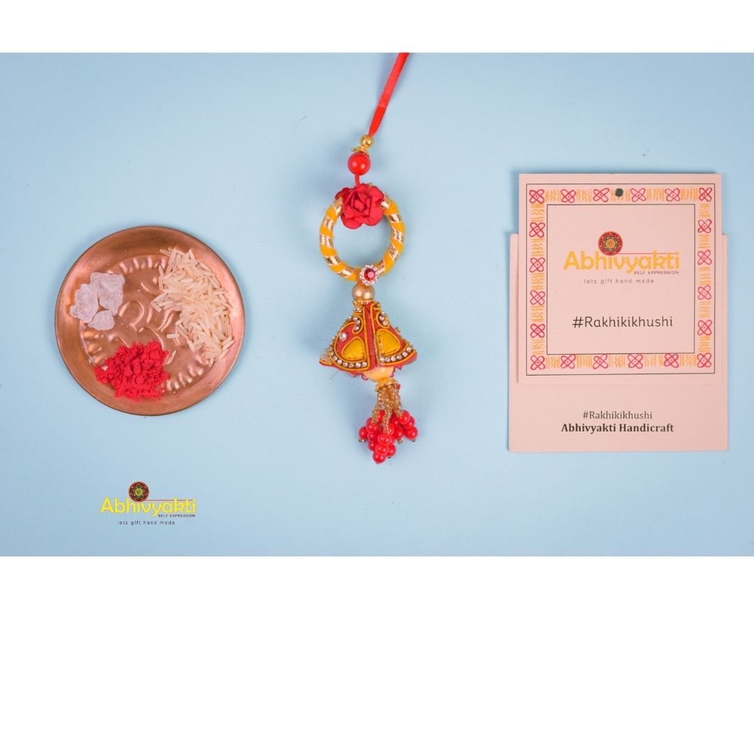 Red and gold featuring a red flower, Rakhi lumba adorned with lovely beads and stone.